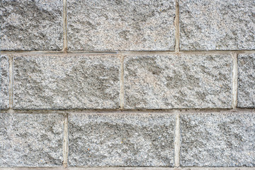 The texture of the gray wall of concrete blocks