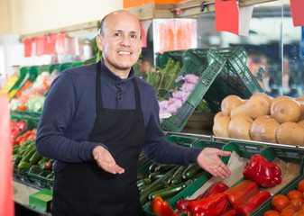 salesman offering pepper  in vegetable department
