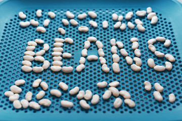Beans written with white beans on a blue serving tray