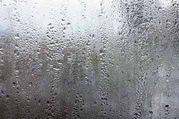 Moisture on the glass, formed in raindrops.