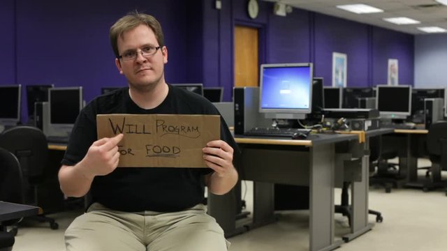 Man begs for work while sitting in computer lab. He is a computer scientist with programming ability.
