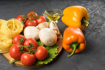 Mushrooms mushrooms, lettuce, tomatoes and spaghetti on stone table.
