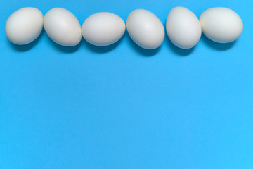 White eggs on blue background, copy space. Healthy food concept. Top view, flat lay. Easter eggs. Happy Easter concept