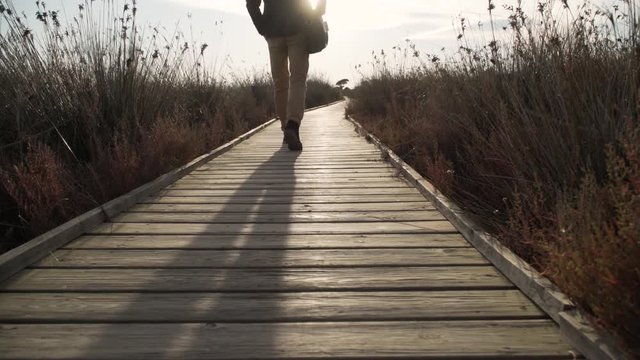 Businessman walking on a pier in the field, relaxation moments.