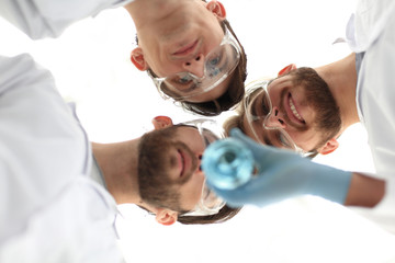 closeup.a group of scientists looks at the liquid in the beaker