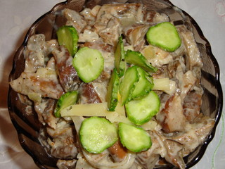 Mushrooms with onions, seasoned with sour cream sauce. Decorated with fresh cucumbers.