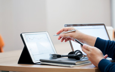 close up investor man hand pointing on tablet at stock market dashboard for check about currency rate exchange