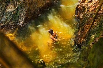 Obraz premium Young woman swimming in a natural tropical pool