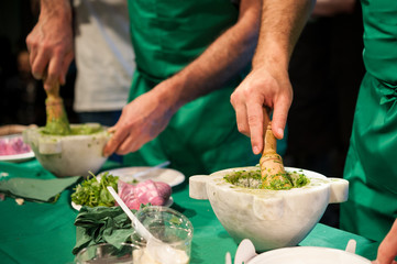People during the preparation of the Pesto basil sauce - obrazy, fototapety, plakaty