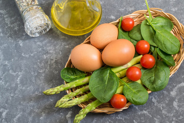 Ingredients for cooking frittata with asparagus, cherry tomatoes and spinach