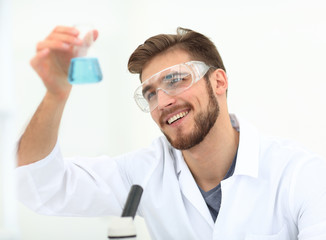 closeup. chemist holding a beaker with a solution