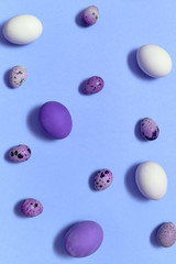 White, violet and quail easter eggs on blue background, copy space. Healthy food concept. Top view, flat lay. Happy Easter concept