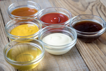 platter of various sauces in glass bowls in the shape of a triangle