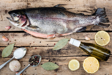Fresh trout fish with spices on wood