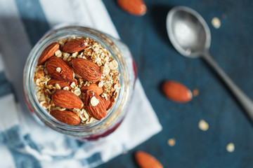 Top view of an organic chia pudding with granola, banana, jam and almonds. The concept of healthy food.