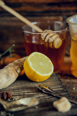 Vitamin medicinal tea with lemon and honey, ginger and spices on wooden background . The concept of spring beriberi and colds.