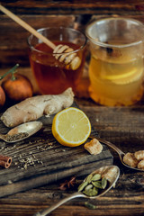 Vitamin medicinal tea with lemon and honey, ginger and spices on wooden background . The concept of spring beriberi and colds.