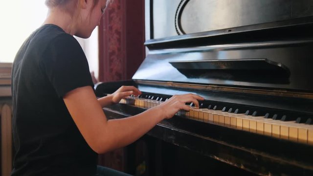 Girl teen plays on the piano