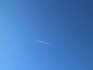 trail of the plane in the blue sky