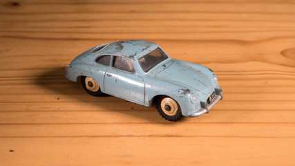 Old retro metal toy car on wooden table 