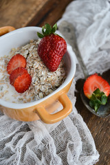 Breakfast: granola with berries fresh strawberries on wooden background natural rustic. The concept of healthy eating.