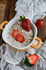Breakfast: granola with berries fresh strawberries on wooden background natural rustic. The concept of healthy eating.