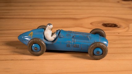 Old retro metal toy race car on wooden table 