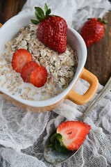 Breakfast: granola with berries fresh strawberries on wooden background natural rustic. The concept of healthy eating.