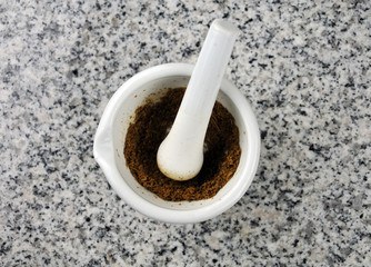 zerriebener Kreuzkümmel in Porzellanmörser