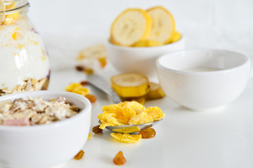 Breakfast in a jar: cereal, banana, fresh berries, granola, yogurt on a light background. The concept of healthy eating, high-carbon Breakfast.