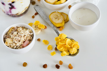 Breakfast in a jar: cereal, banana, fresh berries, granola, yogurt on a light background. The concept of healthy eating, high-carbon Breakfast.