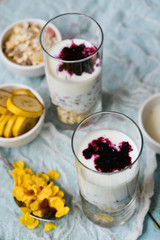 Healthy Breakfast: homemade granola, banana, fresh berries, yogurt in glass cups on light textile background. The concept of healthy eating, high-carbon Breakfast.