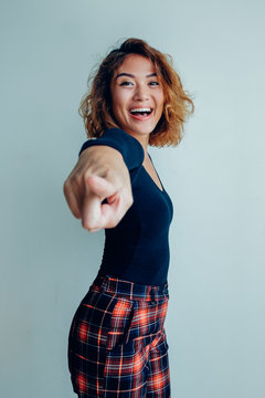 Portrait of smiling Asian woman pointing at camera