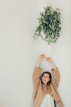 Young woman under cache pot