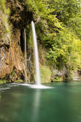 Paradise landscape with waterfall flowing into a pond in Plitvice Lakes National Park in summer in Croatia