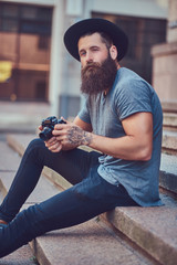 A handsome hipster male with a stylish beard and tattoo on his a