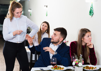 Woman is talking with couple in restaurante