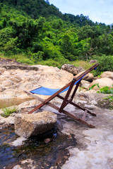 Folding Chair on Stone Platform at Pond in Park
