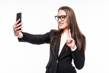 Beautiful playful business woman making selfie with peace gesture on isolated white background