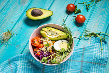 Fototapeta na wymiar Healthy vegan lunch bowl. Vegan buddha bowl. Vegetables and nuts in buddha bowl on blue wood background