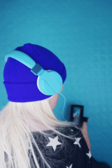 Chica joven con el pelo rubio platino escuchando música con sus auriculares 