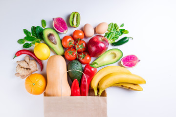 Healthy food background. Healthy food in paper bag fruits and vegetables on white. Vegetarian food. Shopping food supermarket concept. Top view