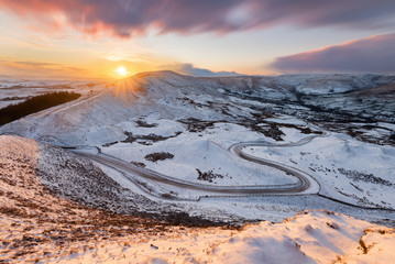 Long winding rural road in the Peak District with snow and beautiful sunset. © _Danoz