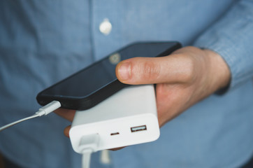 Man charging smartphone with power bank.