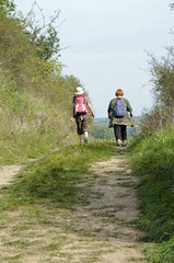 zwei frauen wandern auf einem feldweg