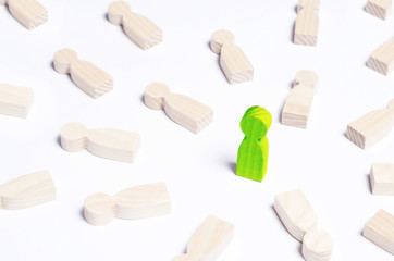 A person is in the spotlight. A green wooden figure of a man. Concept business idea. Best in the business. People lie around. Victory, progress, innovation.