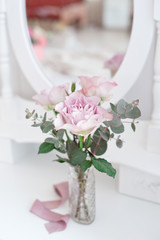 bouquet of three roses in vase against mirror on background.