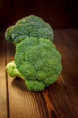 Big and ripe broccoli florets on wooden table.