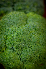 Obraz premium Big and ripe broccoli florets on wooden table.