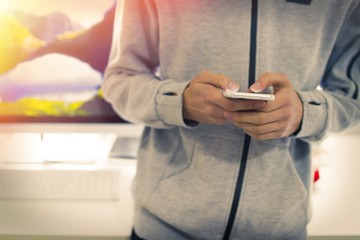 young man with mobile phone in hand typing